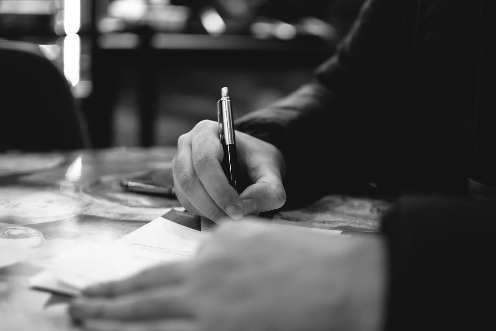 A hand writing a letter on plain paper